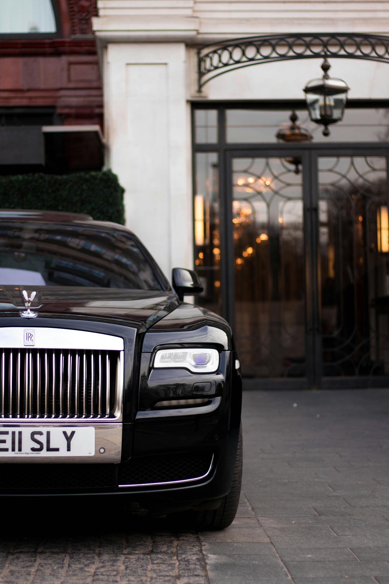 Black Rolls-Royce at the entrance of a London grand hotel at dusk